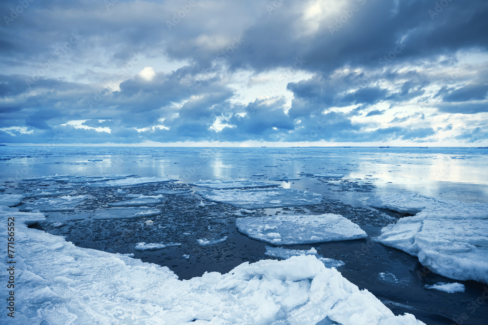 Naklejka premium Winter coastal landscape with floating melting ice fragments