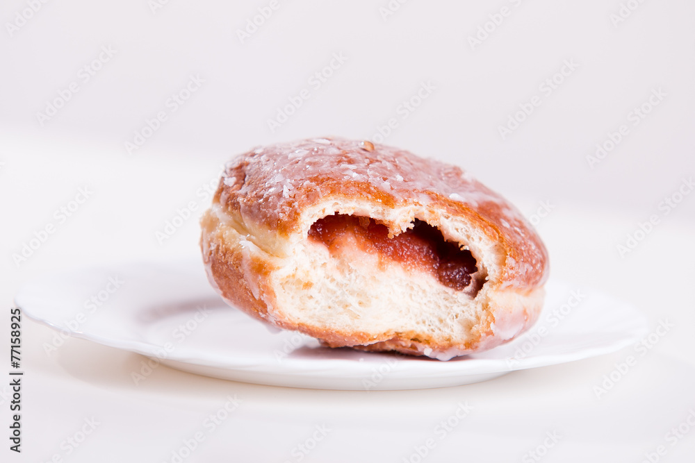 Bitten donut with jam lies on a plate Bitten donut with jam lies on a plate
