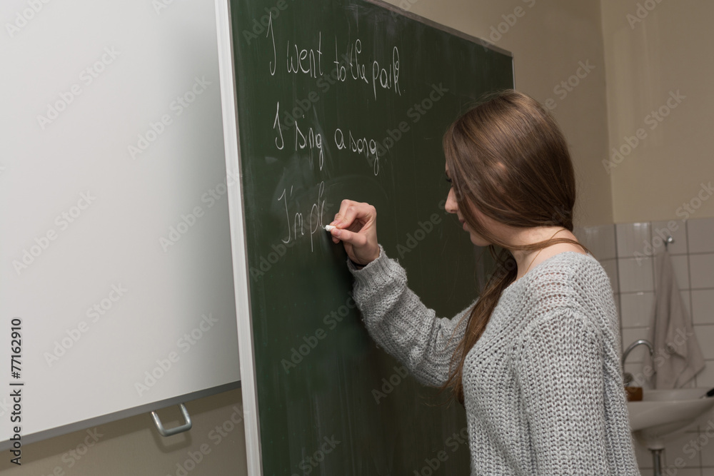 Teenager schreibt an der Tafel Teenager schreibt an der Tafel