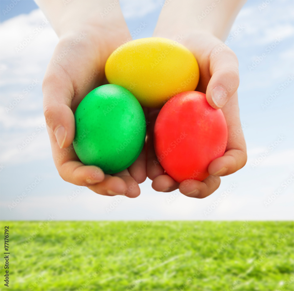 close up of kid hands holding colored eggs close up of kid hands holding colored eggs