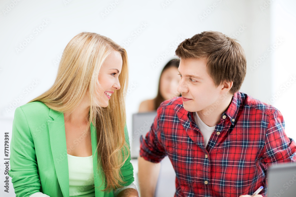 smiling students looking at each other at school smiling students looking at each other at school