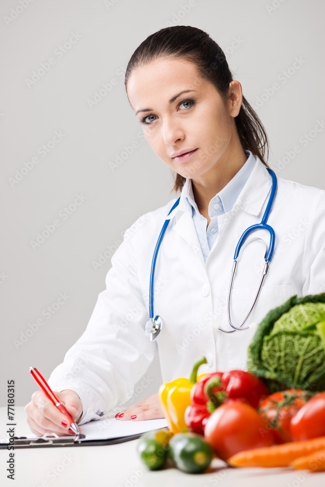Smiling nutritionist writing medical prescriptions Smiling nutritionist writing medical prescriptions