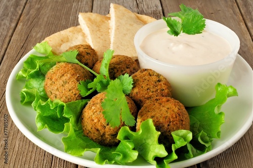 Plate of falafel on lettuce with pita bread and tzatziki sauce