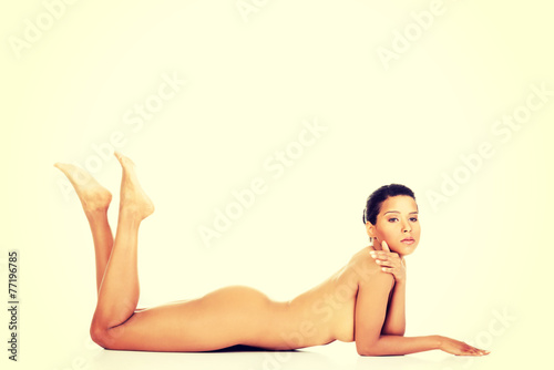 Woman lying on her belly with legs up.