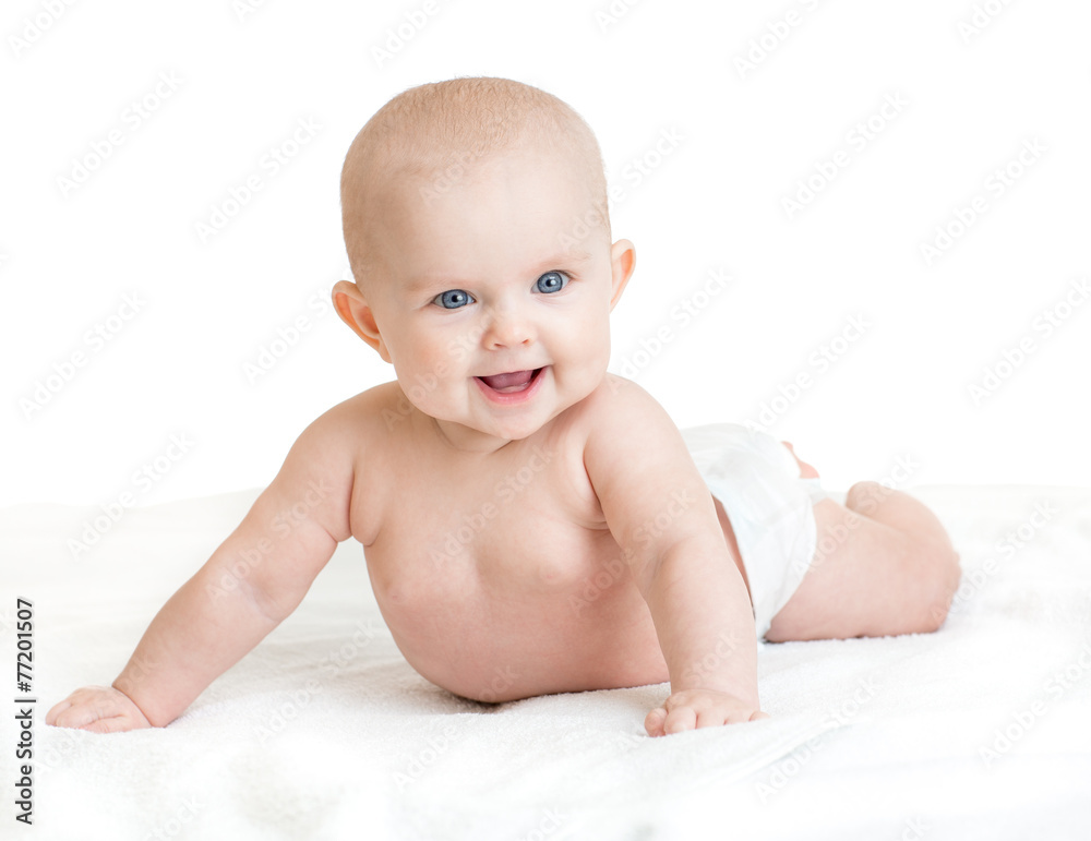 Cute smiling baby lying on white towel in nappy Cute smiling baby lying on white towel in nappy