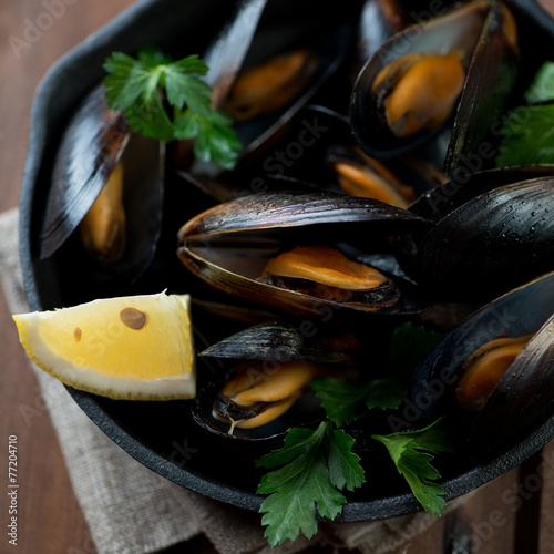 Close-up of steamed mussels with parsley and lemon