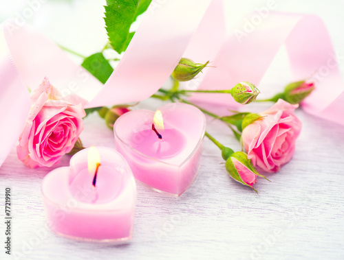 Valentines Day. Pink heart shaped candles and rose flowers