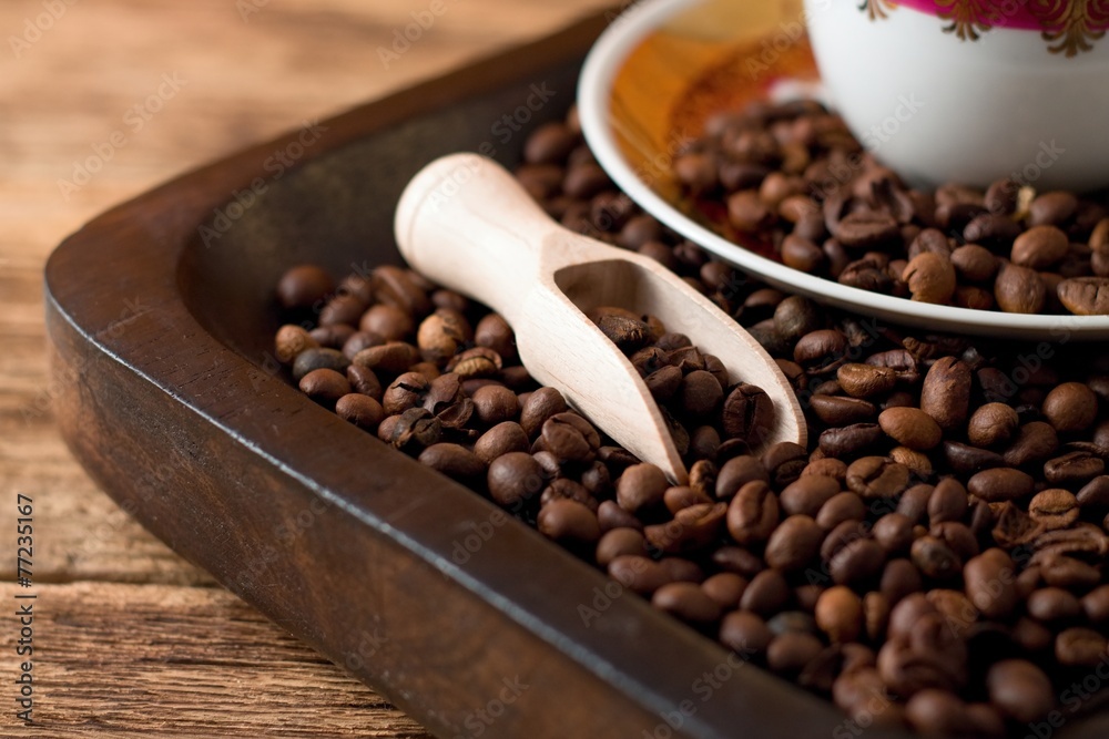 Fototapeta premium Coffee grains on tray from dark wood