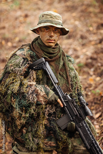 soldier stands with arms and looks forward