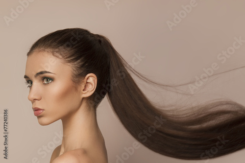 Beautiful woman with long healthy brown ponytail photo