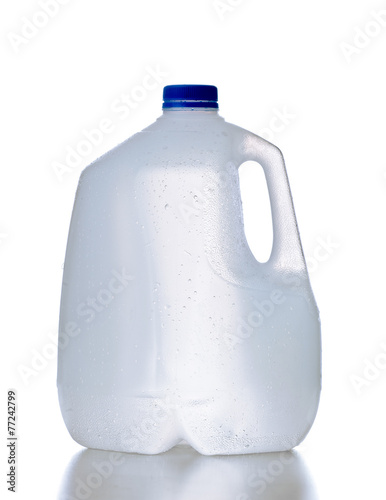 Plastic jug, recyclable and reusable bottle jug container for water, milk and other liquids with no tag and drops on the surface, isolated on white background with reflection