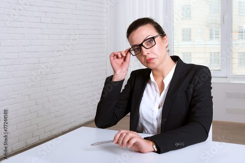 Woman looking disdainfully lifting eye glasses