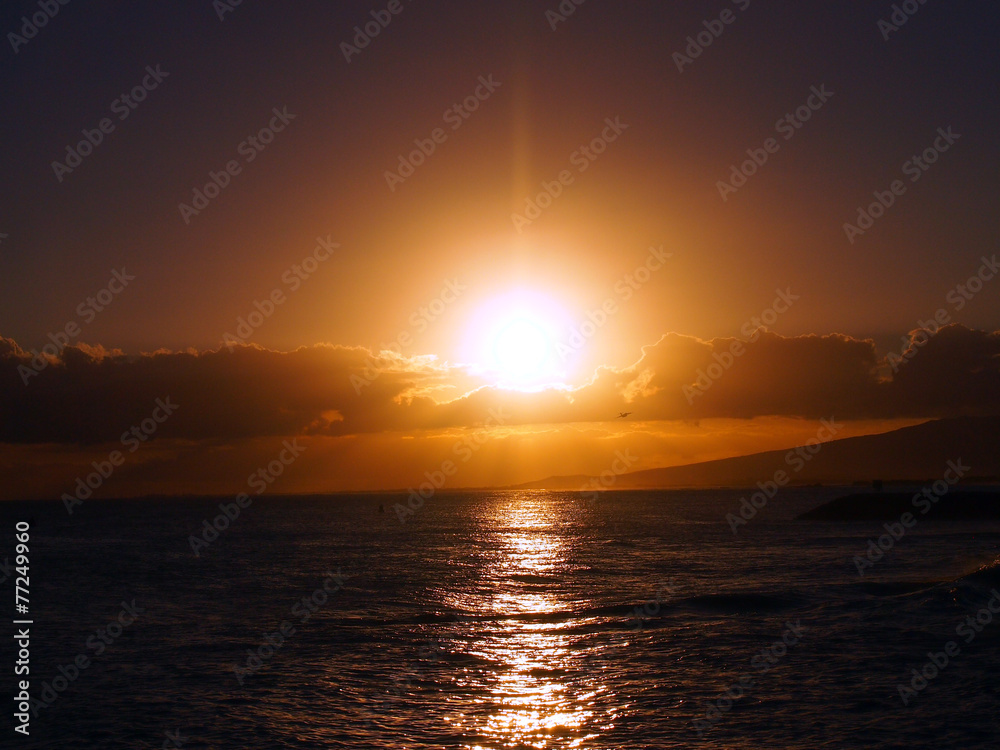 Dramatic Sunset over the clouds and reflecting on the Pacific oc