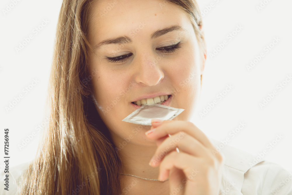 toned portrait of sexy brunette woman holding condom toned portrait of sexy brunette woman holding condom