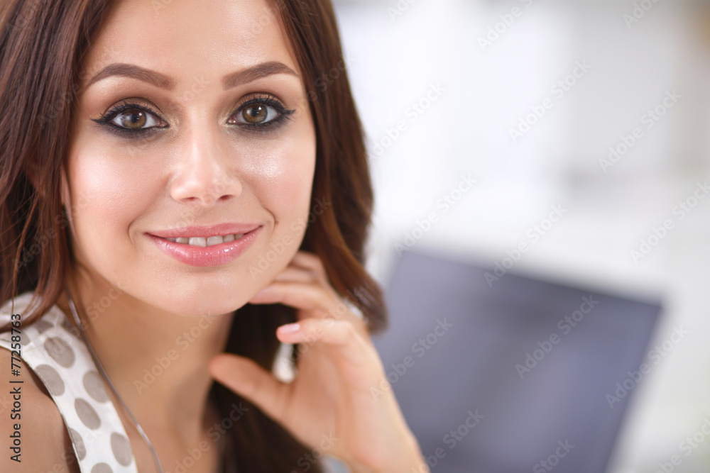 Attractive businesswoman sitting on desk in the office Attractive businesswoman sitting on desk in the office