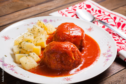 Meatballs in tomato with boiled potatoes on plate