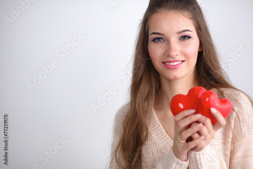 Portrait of beautiful happy woman holding a symbol heart.
