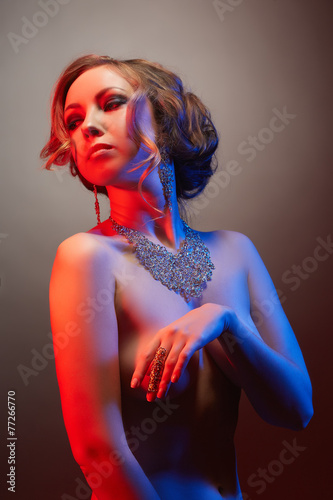 Portrait of pretty nude model advertises jewelry