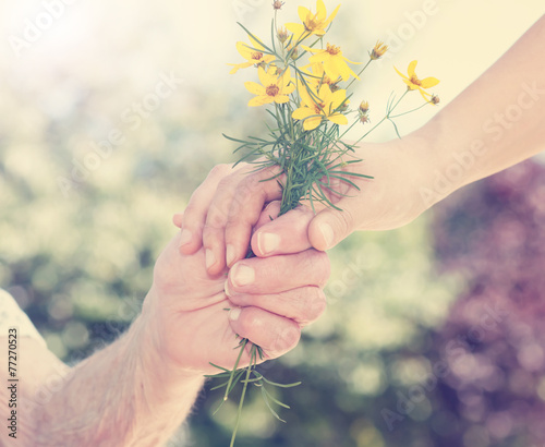 Elderly and young woman holding flowers outside #77270523