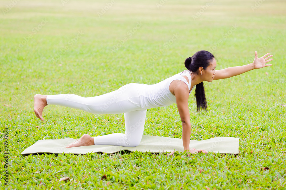 Fototapeta premium Beautiful woman practicing yoga in the park
