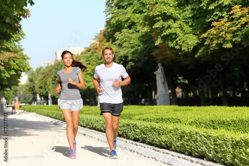 Running couple runners jogging in city park