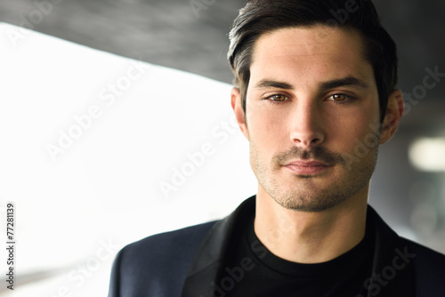 Attractive young businessman in urban background