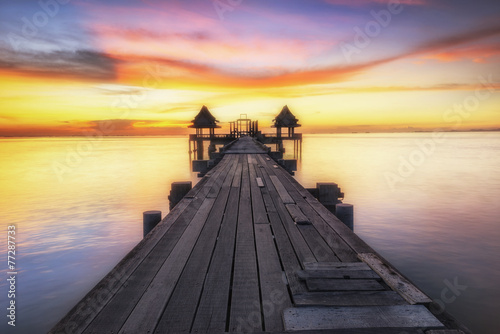 Wooded bridge in the port between sunrise. © weerasak