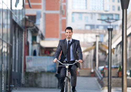businessman riding bicycle on street