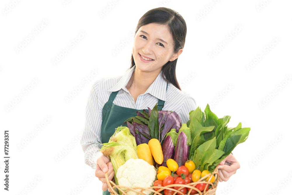 野菜を持つ笑顔の女性