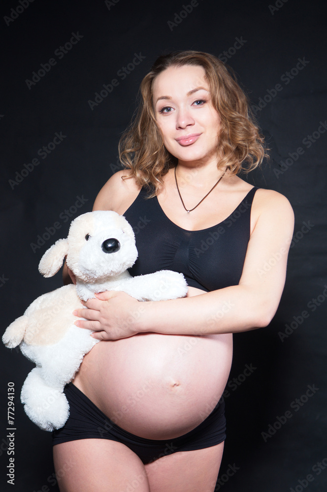 a pregnant woman with toy on the black background a pregnant woman with toy on the black background