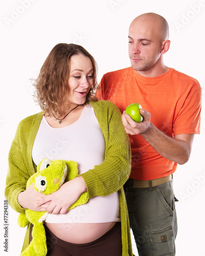 the pregnant woman with her husbend and with green apple photo