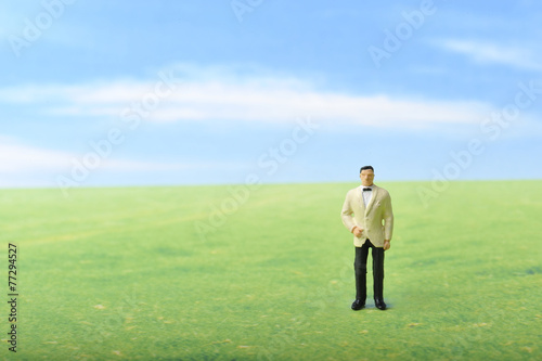 草原に佇むタキシードの男性