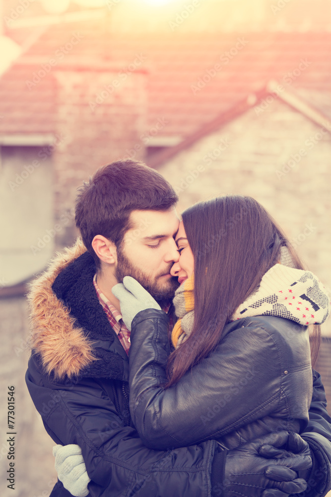 Couple kissing outdoors.