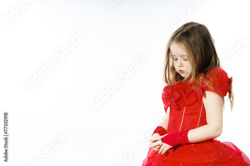 Cute little girl dressed in red posing in studio