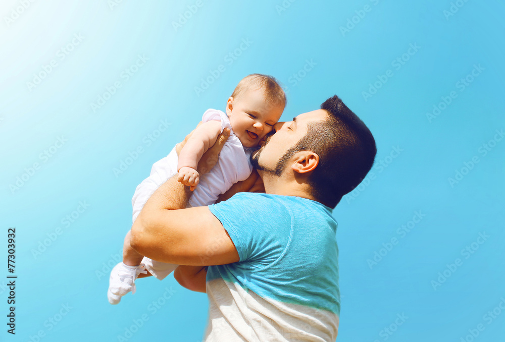 Lifestyle family photo happy father kissing baby outdoors - obrazy, fototapety, plakaty 
