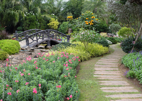 landscape of floral gardening with pathway and bridge in garden