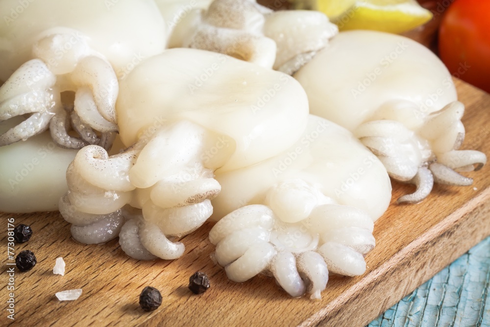 Raw babies cuttlefish on a cutting board closeup Raw babies cuttlefish on a cutting board closeup