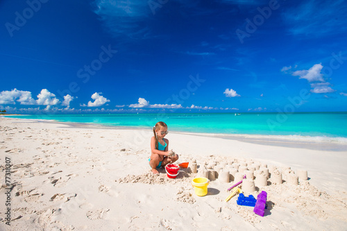 Little girl playing with beach toys during tropical vacation