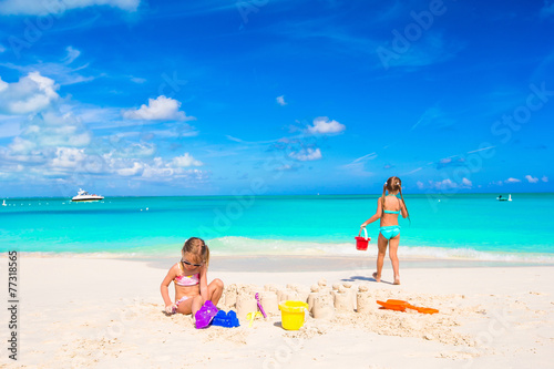 Little sisters playing with beach toys during tropical vacation
