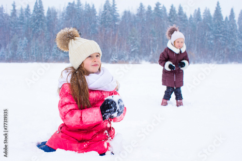 Adorable little girls outdoors on winter snow day