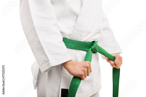 Young girl tying her karate belt