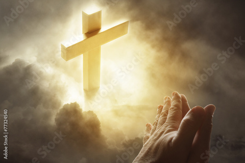 Prayer hands and cross in heavenly sky