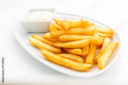 Fried potatoes on white plate with sauce