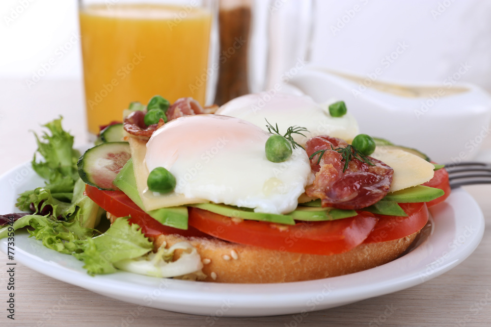 Sandwich with poached eggs, bacon and vegetables