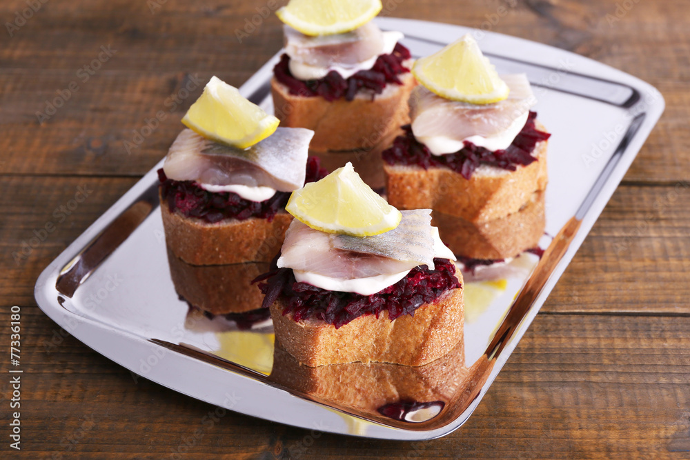 Rye toasts with herring and beets on tray on wooden background Rye toasts with herring and beets on tray on wooden background