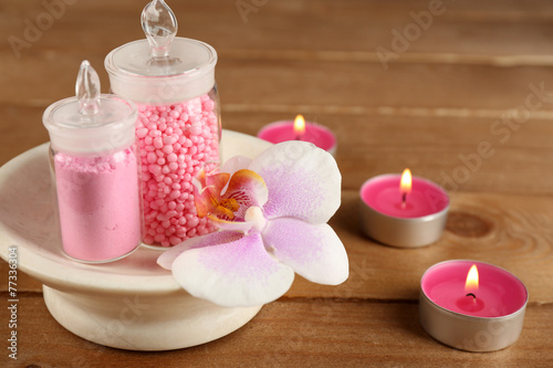 Sea salt and orchid in bowl on wooden background