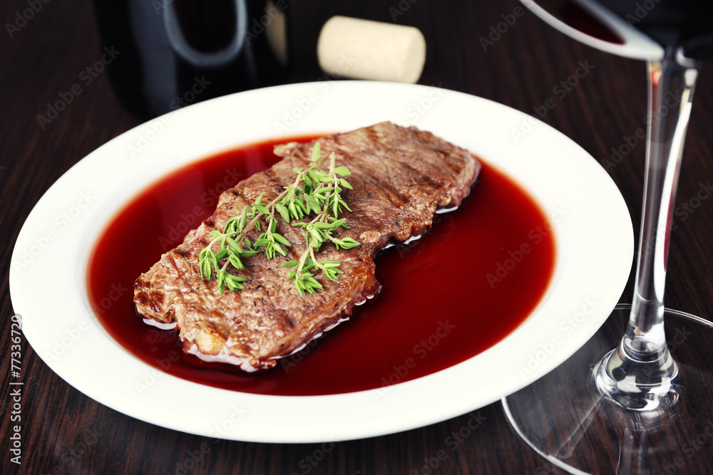 Glass of wine with steak on wooden background Glass of wine with steak on wooden background