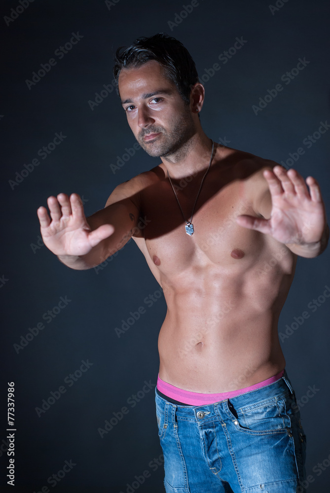 Fototapeta premium Muscle sexy man posing on bark background, showing his muscles