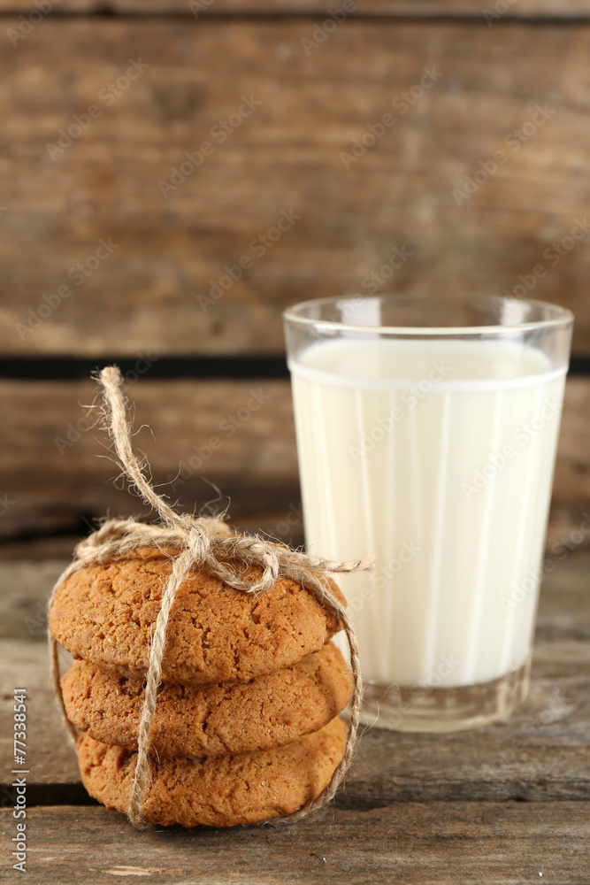 Tasty cookies and glass of milk on rustic wooden background