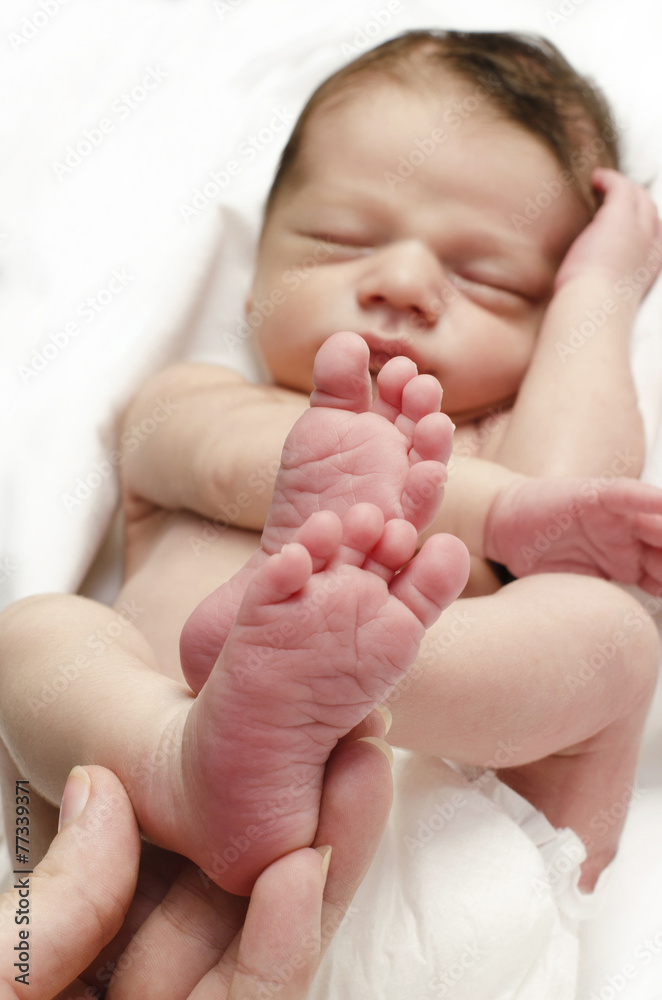 Hand of the mother holding the newborn baby boy little feet up. Hand of the mother holding the newborn baby boy little feet up.